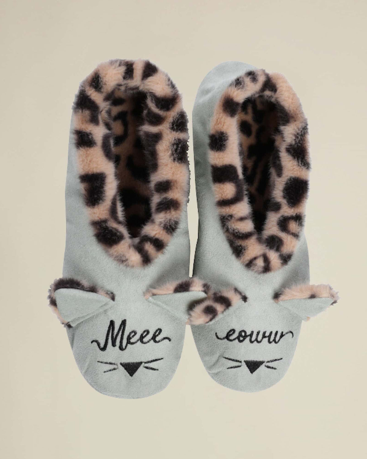 A pair of blue house slippers with a leopard print inner sole and cat face details on the top, with the words 'Meow' printed on the front.