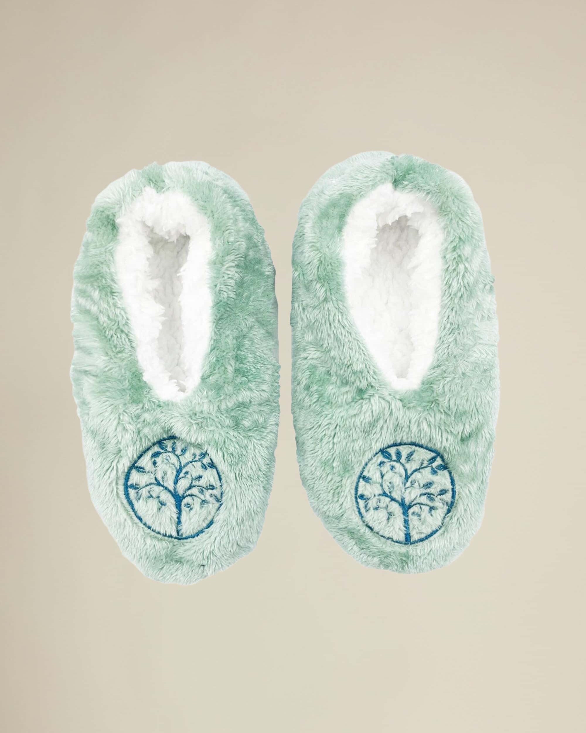 A pair of green cozy slippers with a Tree of Life pattern on the top, designed for women.
