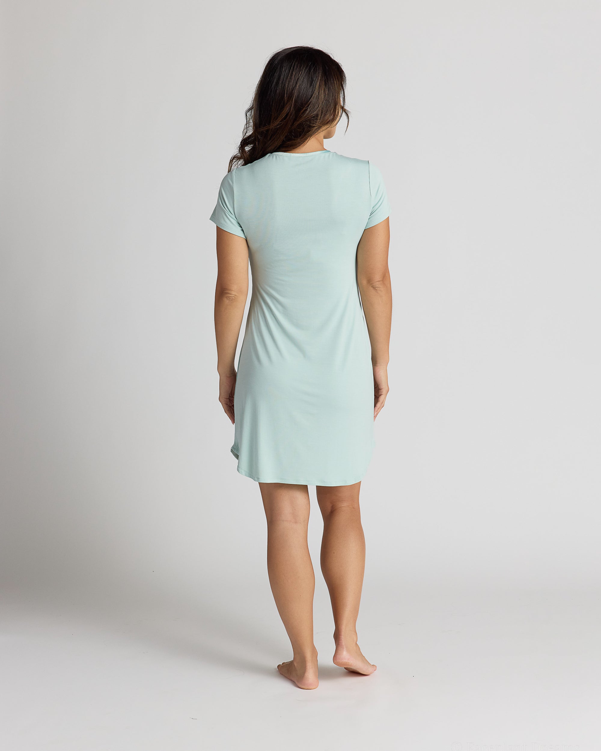 Woman wearing a light blue dress against a plain background