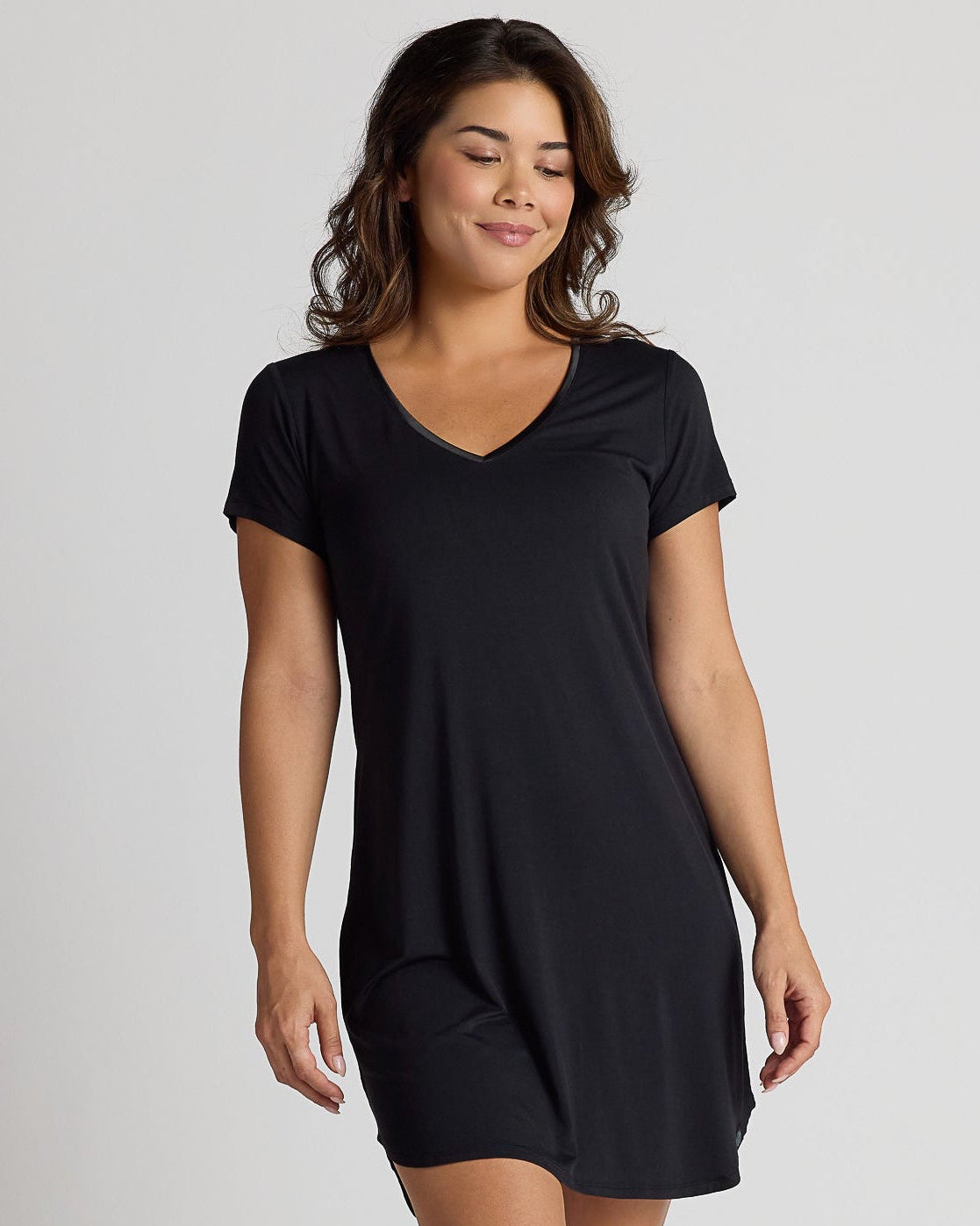 Woman wearing a black dress on a plain background