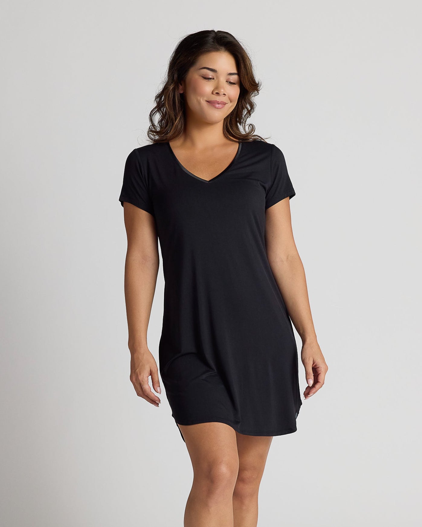 Woman wearing a black dress on a plain background