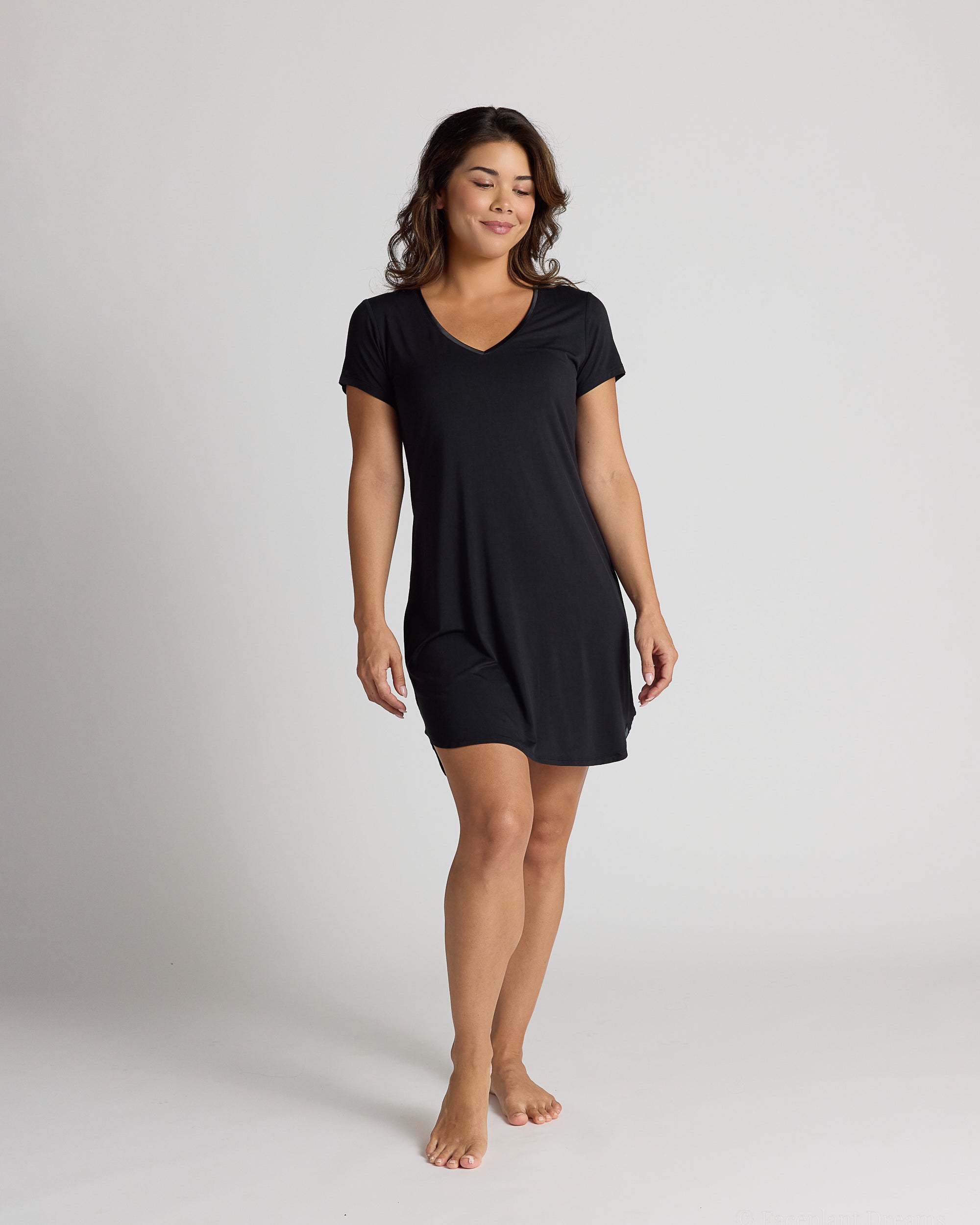 Woman wearing a black dress on a plain background