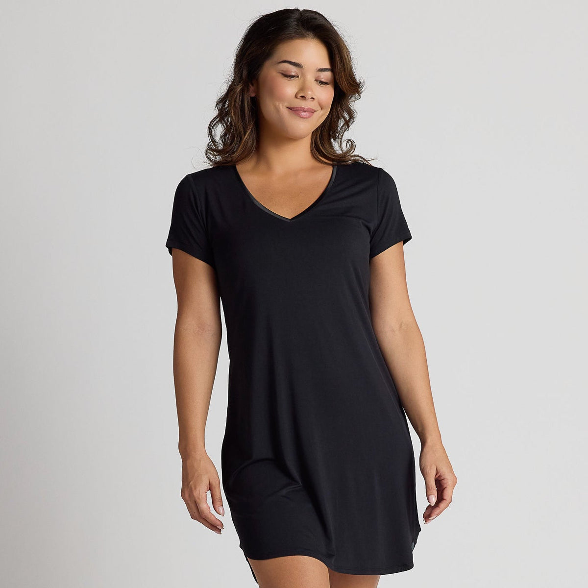 Woman wearing a black dress on a plain background