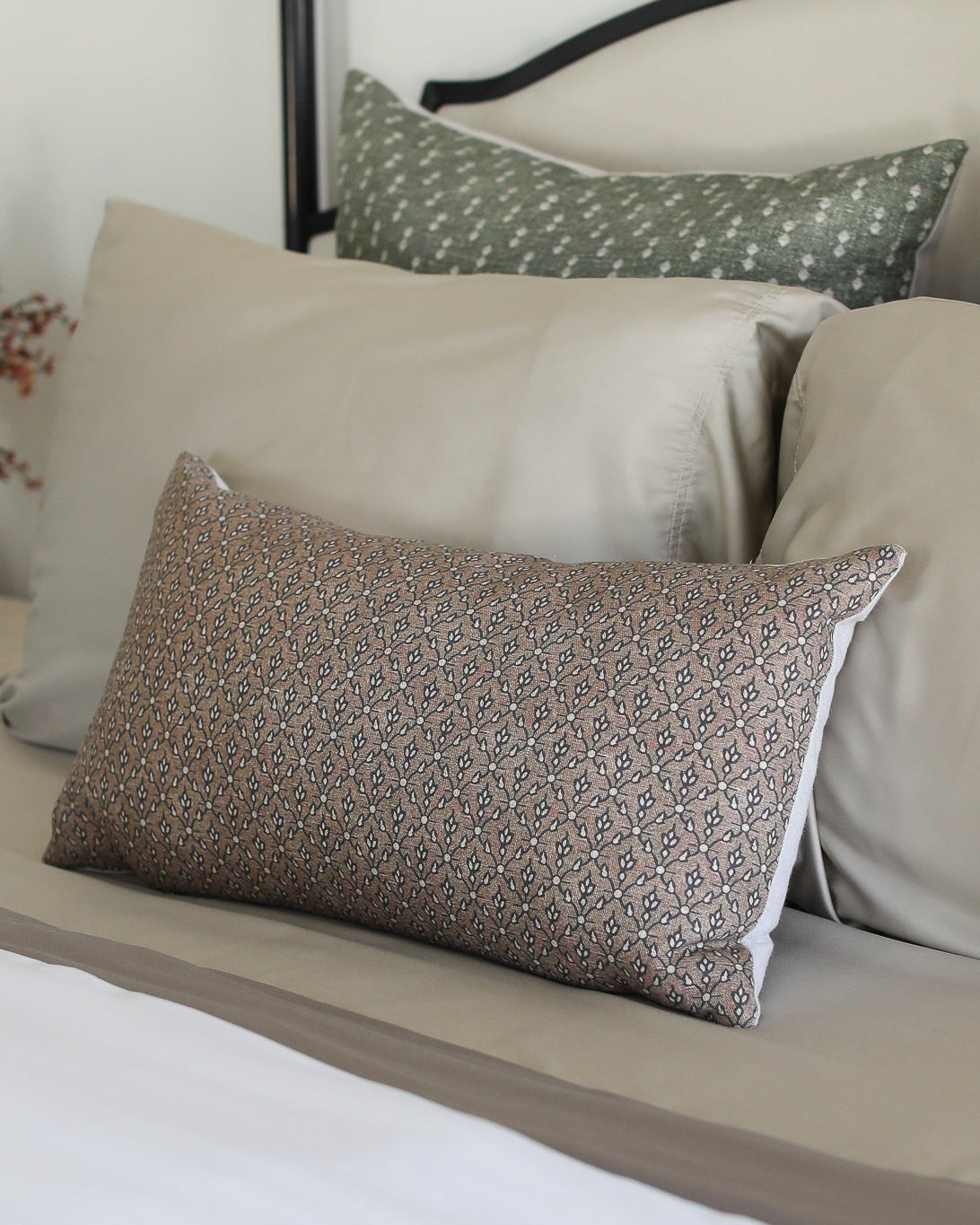 Neatly arranged pillows on a bed with a neutral color scheme.