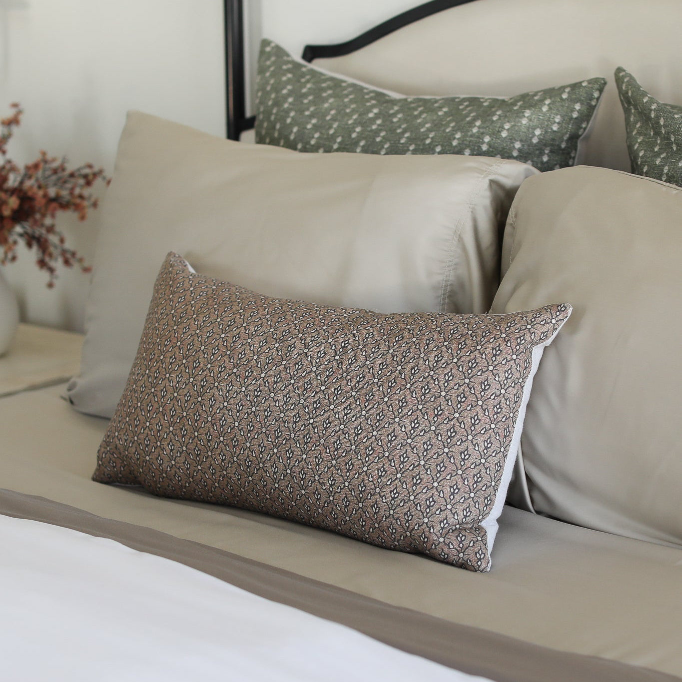 Neatly arranged pillows on a bed with a neutral color scheme.