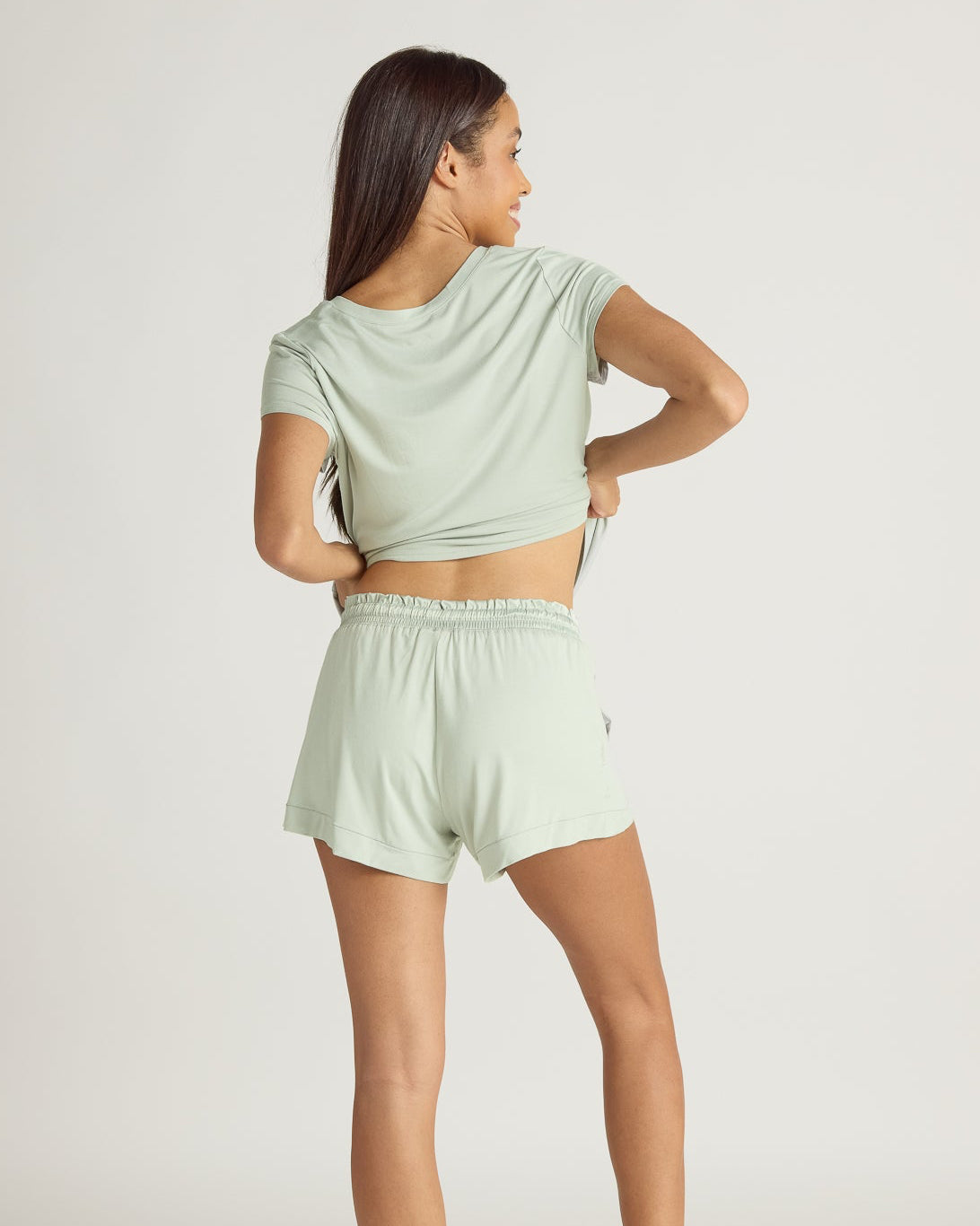 Light green shorts worn by a person on a plain background