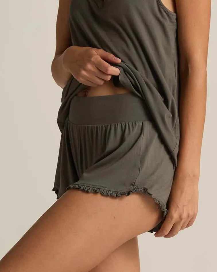 A pair of grey ruffle shorts with an elastic waistband and loose leg openings with ruffled edge detail.