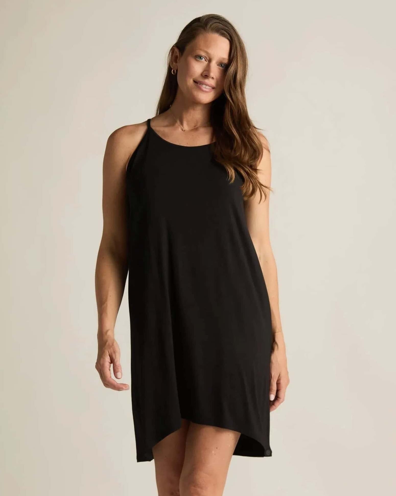 Woman wearing a black sleeveless nightgown against a plain background