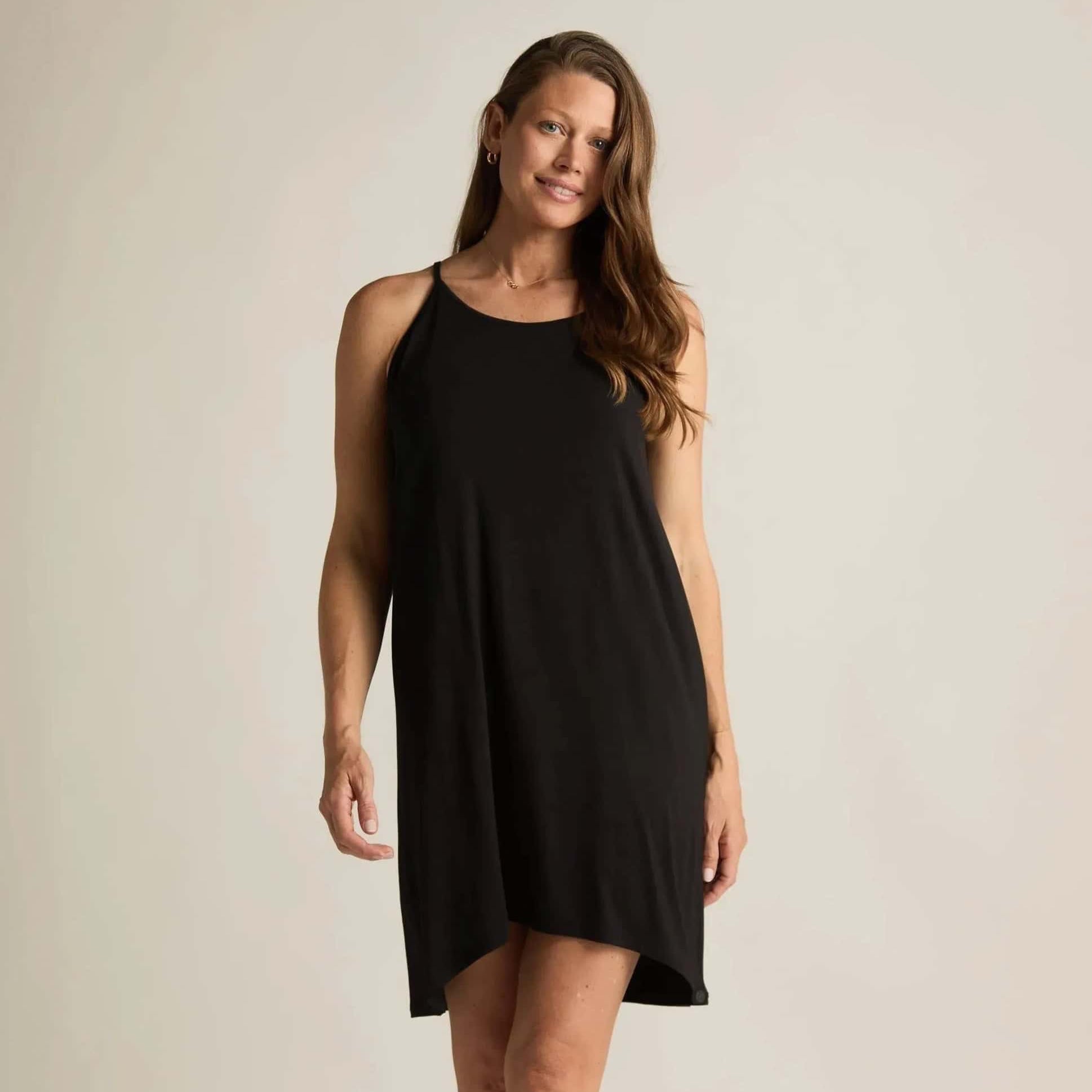 Woman wearing a black sleeveless nightgown against a plain background