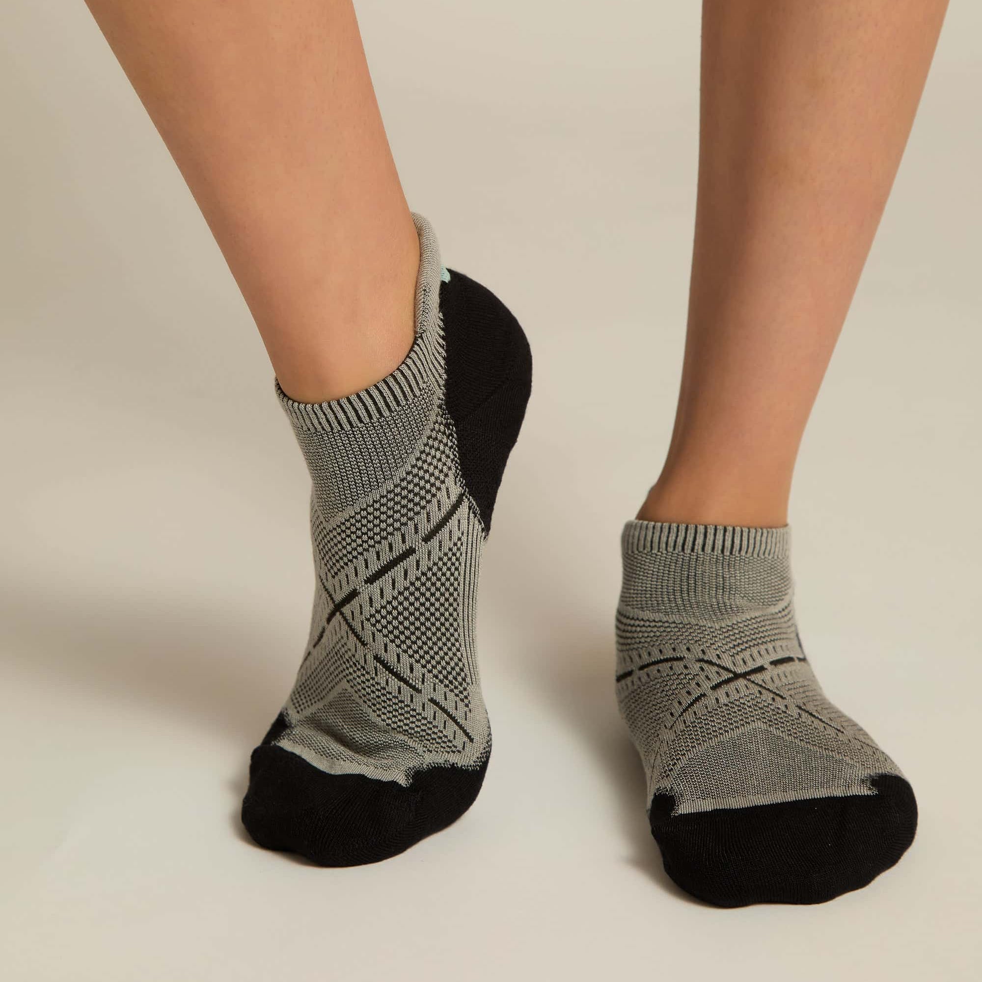 A pair of gray ankle socks with a geometric pattern, featuring black at the toe and heel sections.