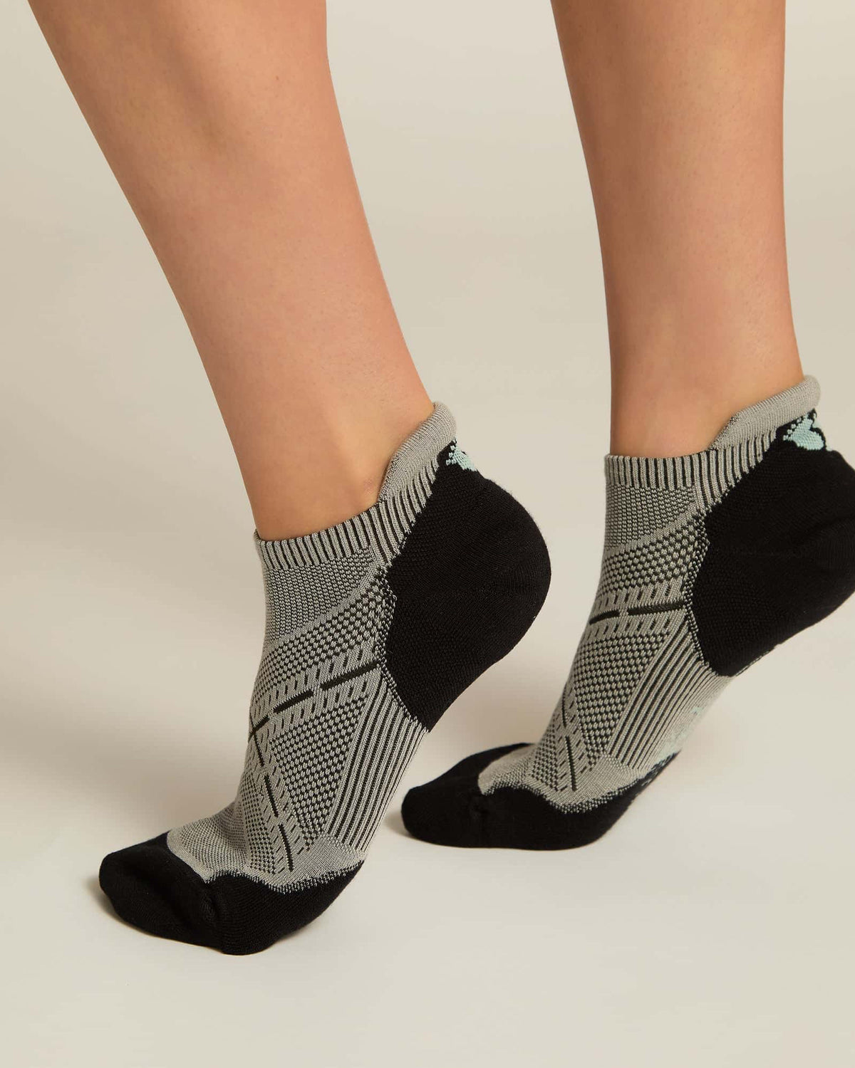 A pair of gray ankle socks with a geometric pattern, featuring black at the toe and heel sections.