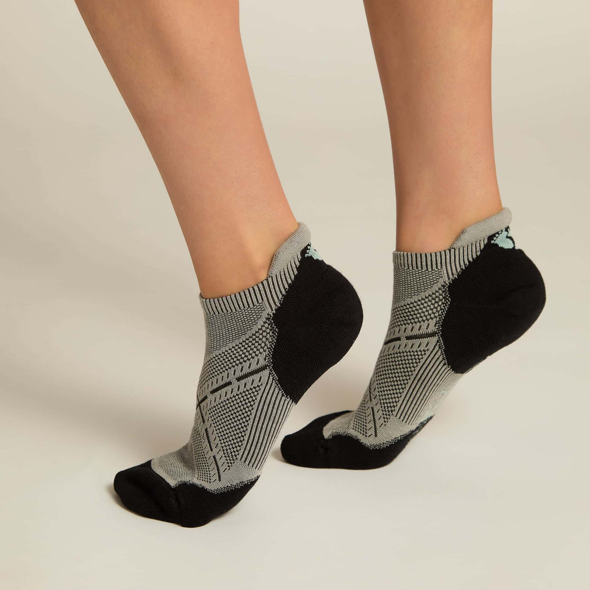 A pair of gray ankle socks with a geometric pattern, featuring black at the toe and heel sections.