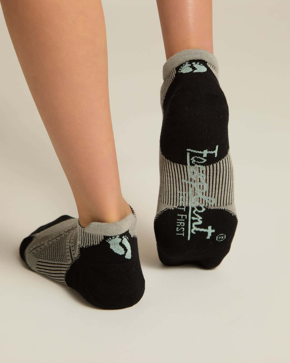 A pair of gray ankle socks with a geometric pattern, featuring black at the toe and heel sections.