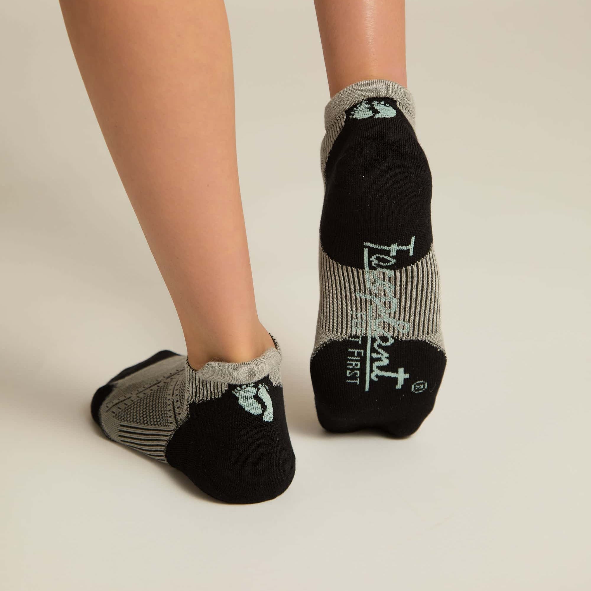 A pair of gray ankle socks with a geometric pattern, featuring black at the toe and heel sections.