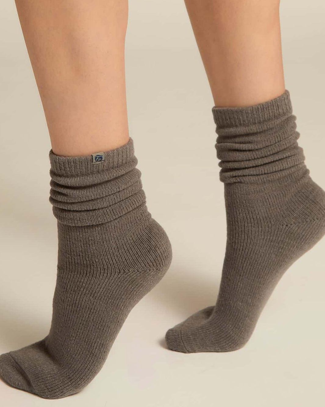 Gray socks worn by a person on a beige background