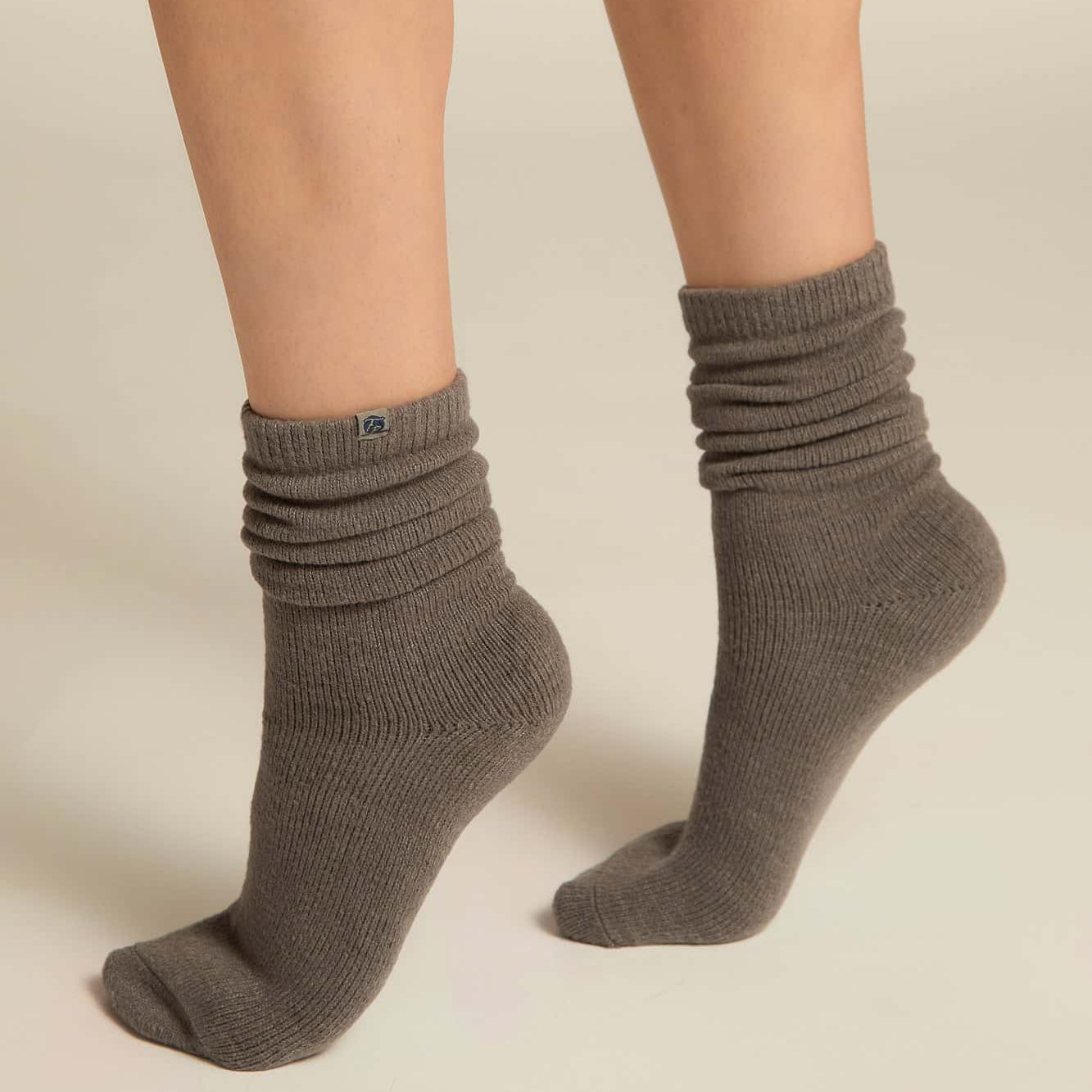 Gray socks worn by a person on a beige background