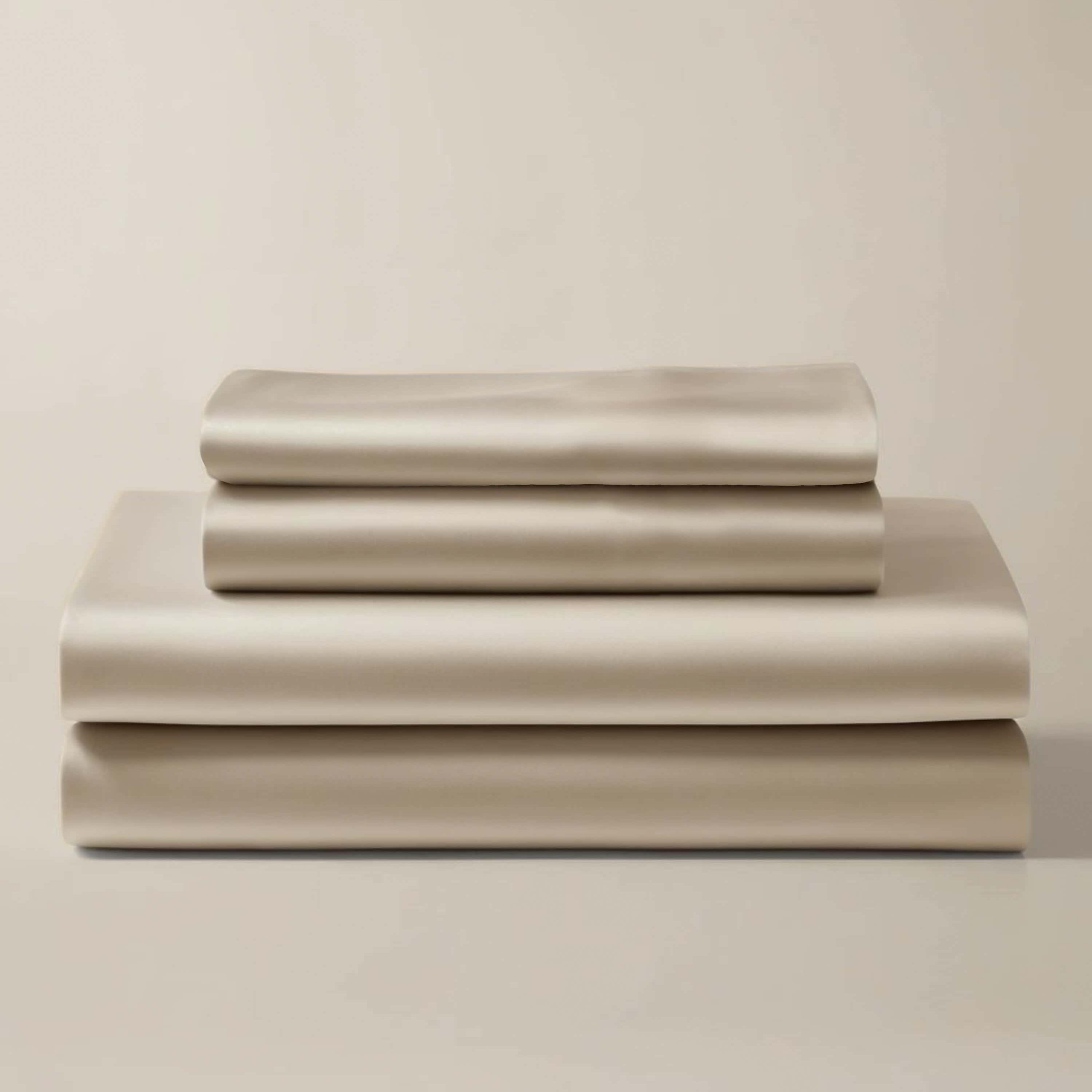 Stack of folded beige bamboo sheets and pillowcases.