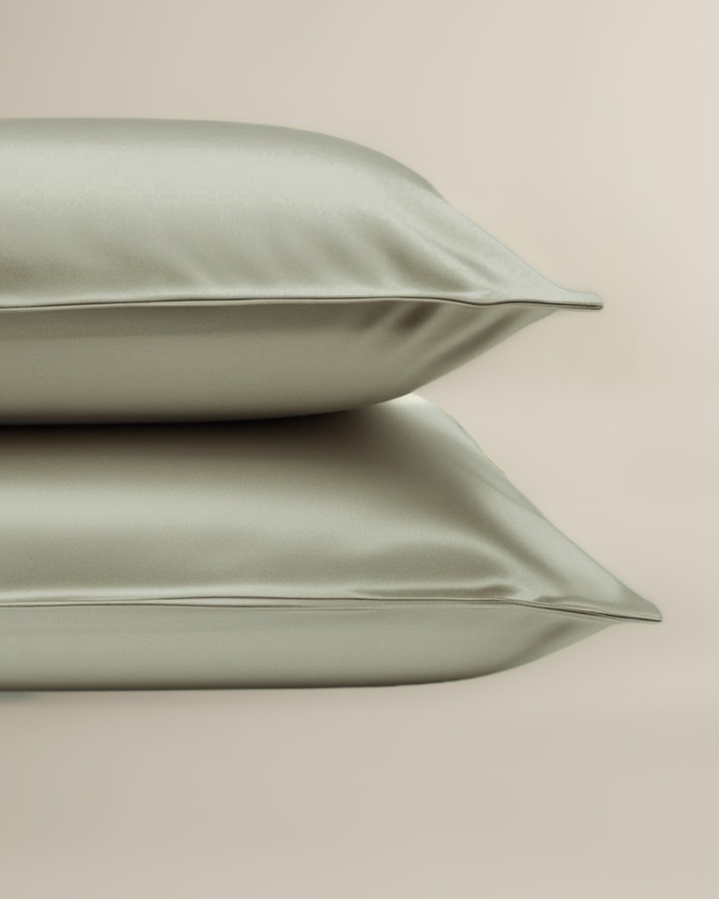 Two green pillows on a beige background