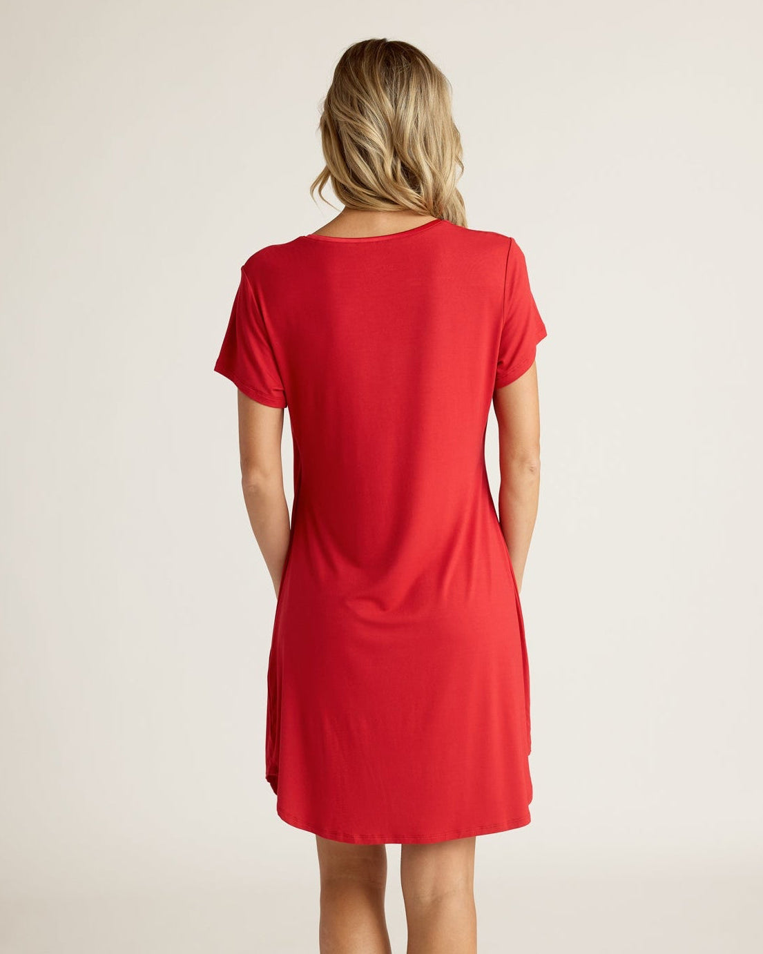 Woman wearing a red dress on a plain background