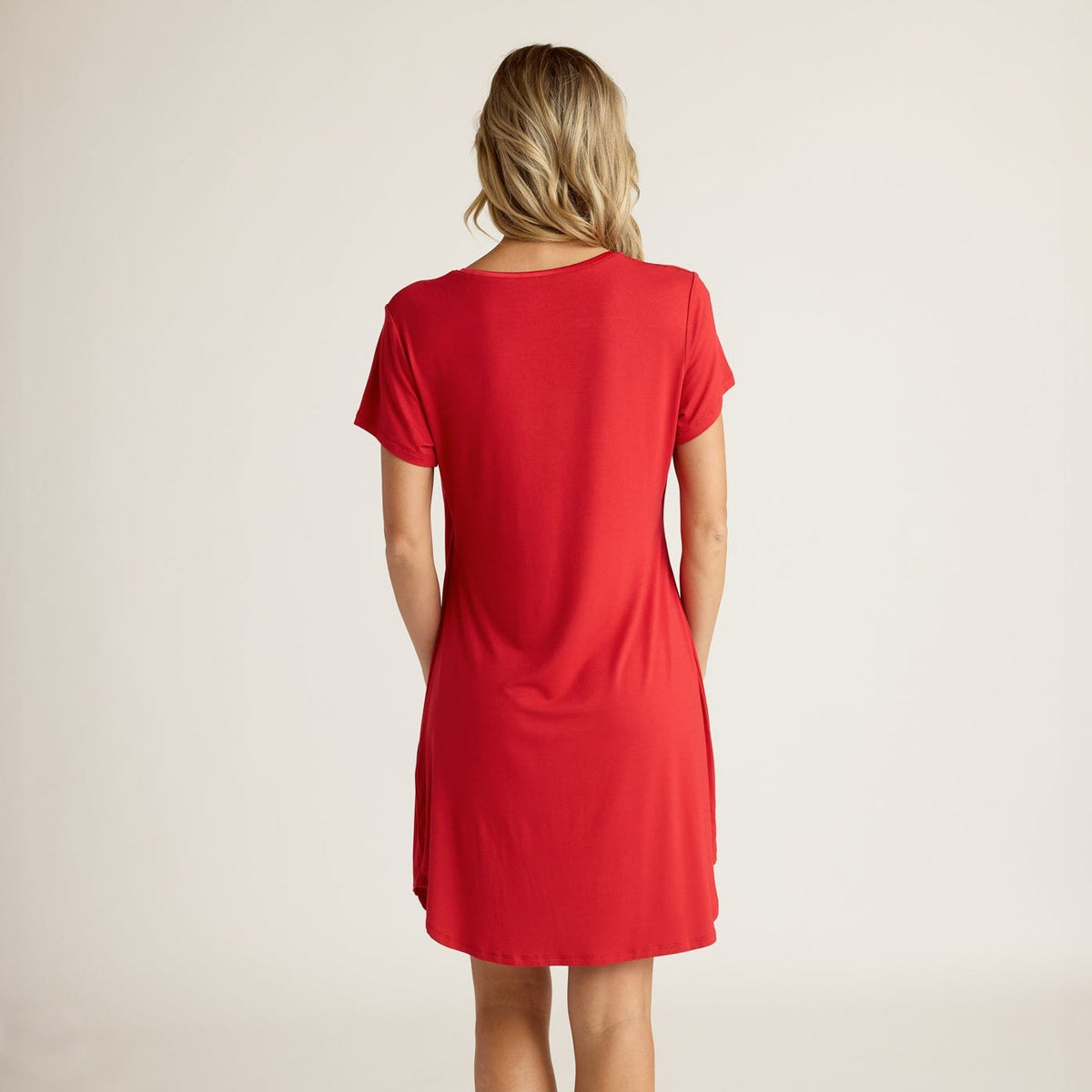 Woman wearing a red dress on a plain background