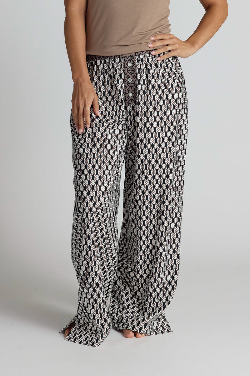 Person wearing patterned pajama pants on a plain background