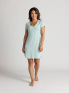 Woman wearing a light blue nightshirt on a plain background
