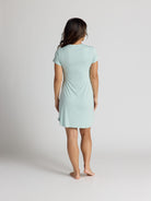 Woman wearing a light blue dress against a plain background
