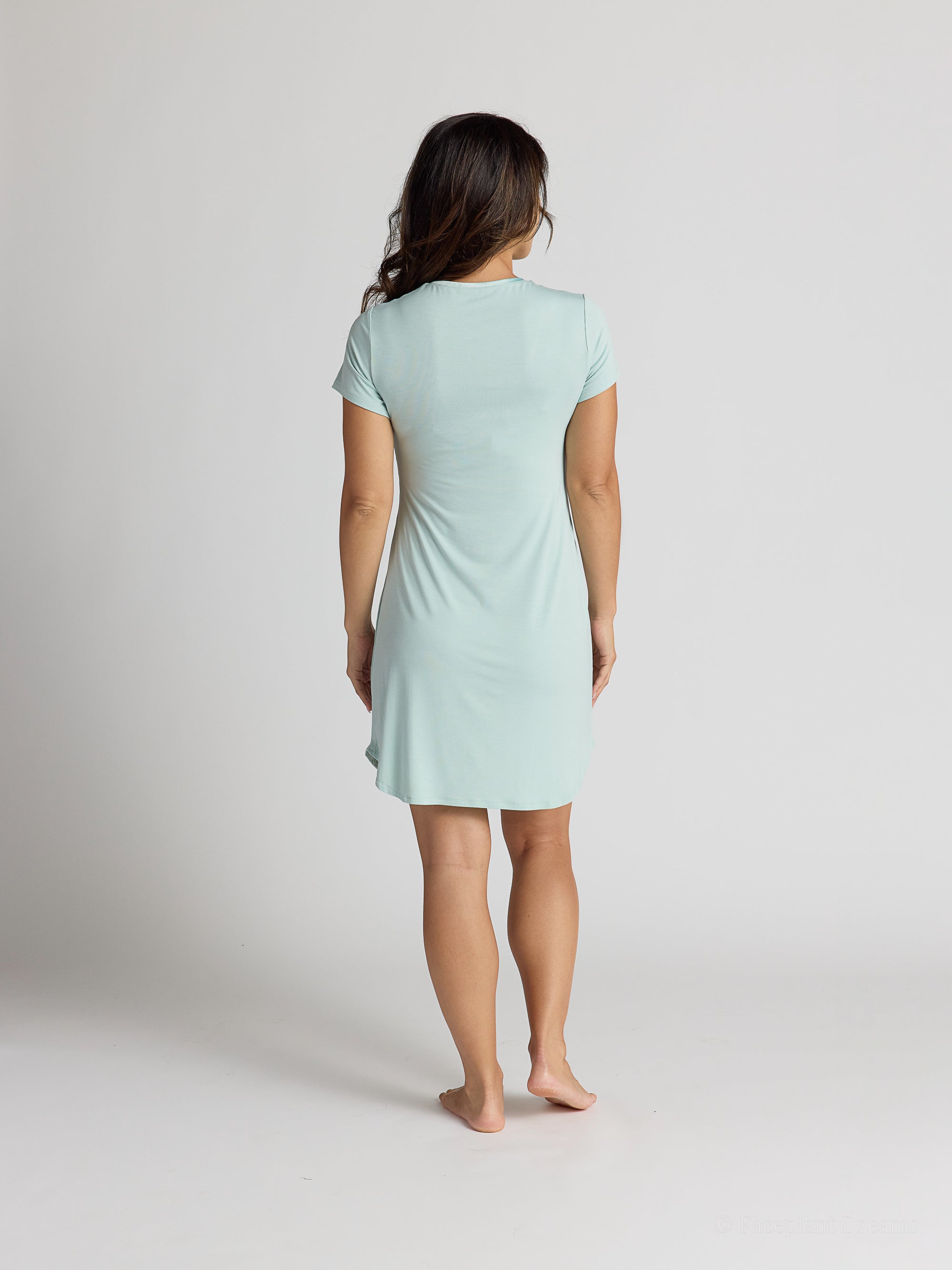 Woman wearing a light blue dress against a plain background