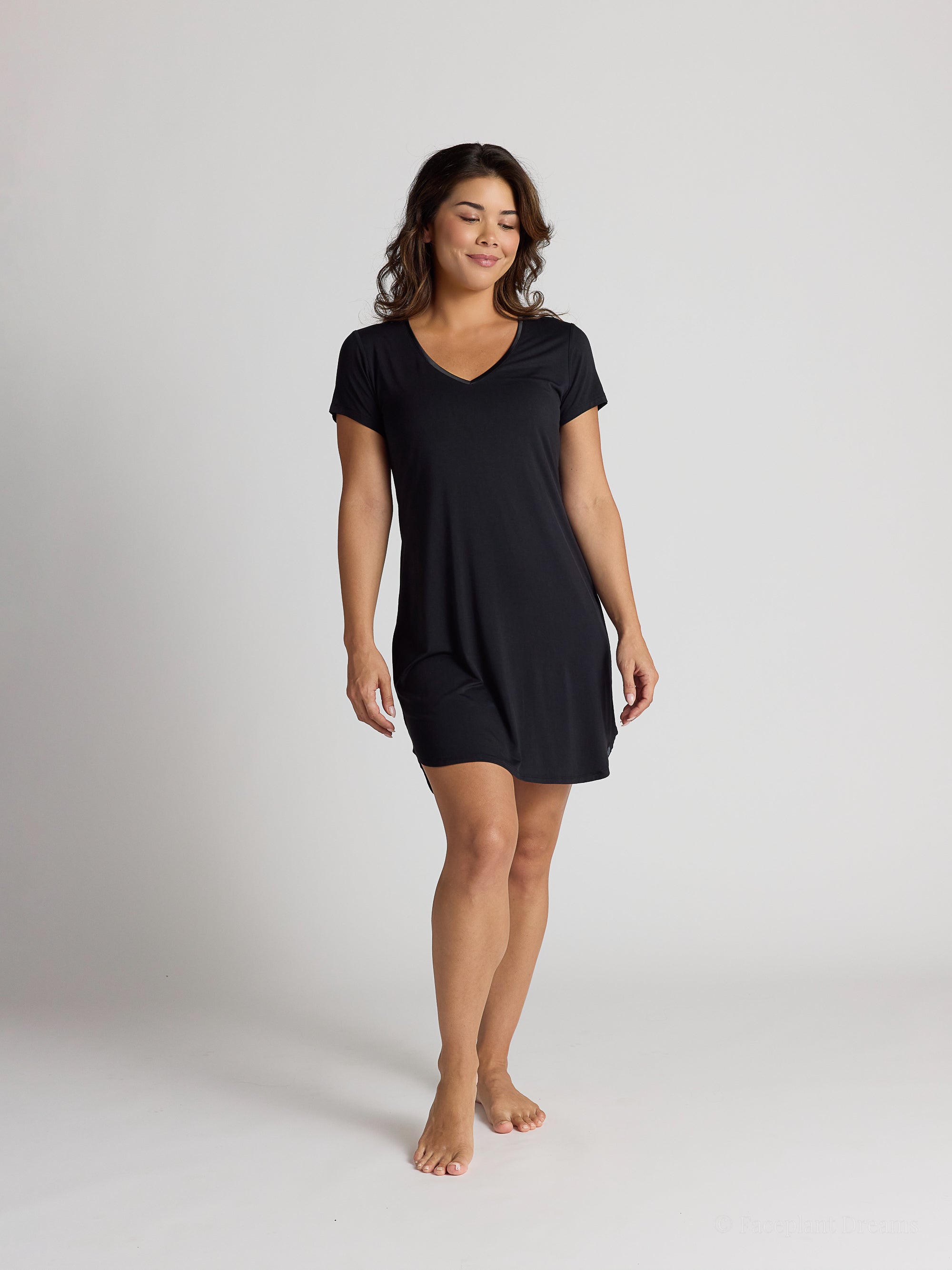 Woman wearing a black dress on a plain background