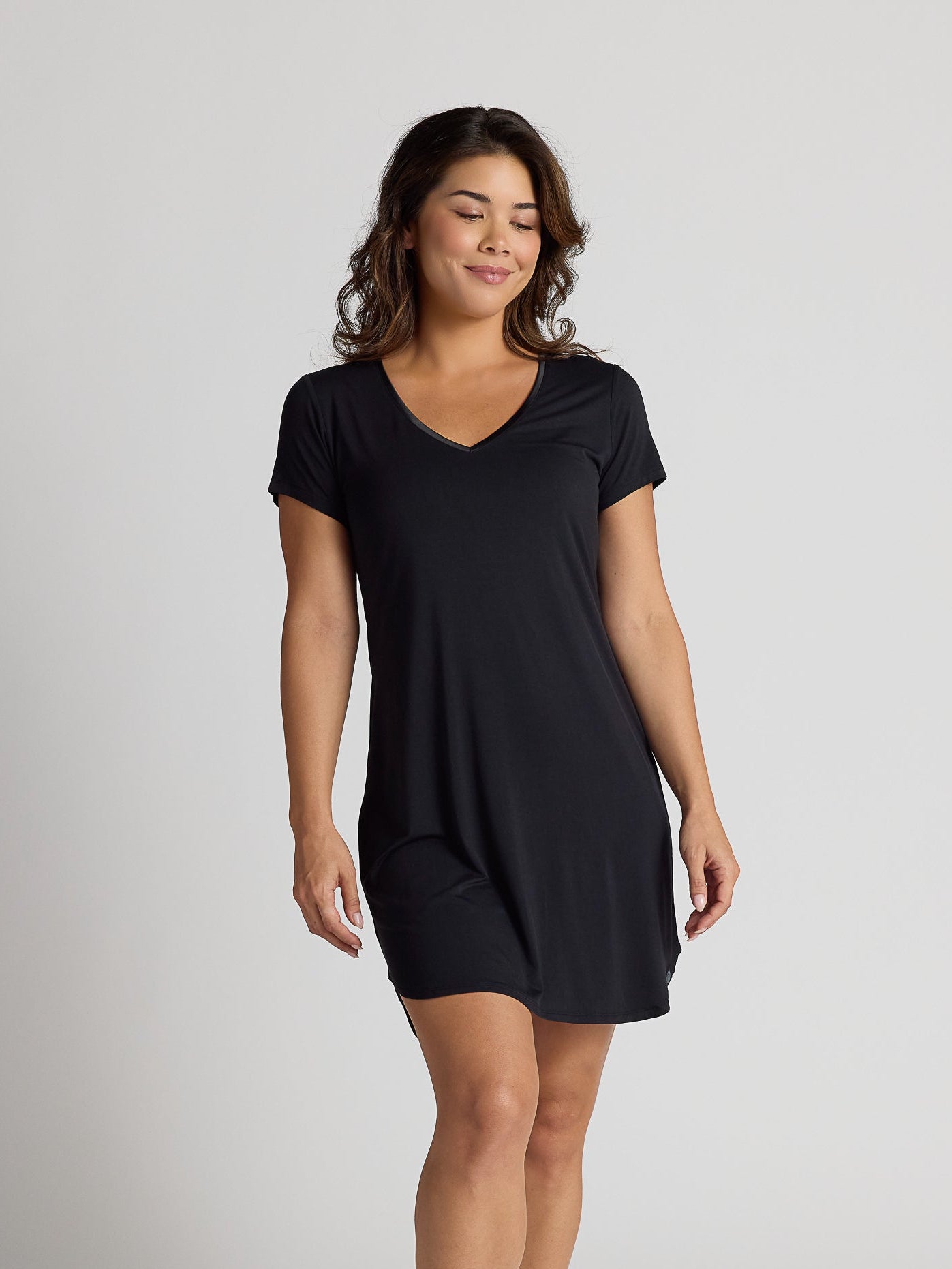 Woman wearing a black dress on a plain background