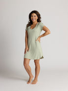 Woman wearing a light green nightshirt on a plain background