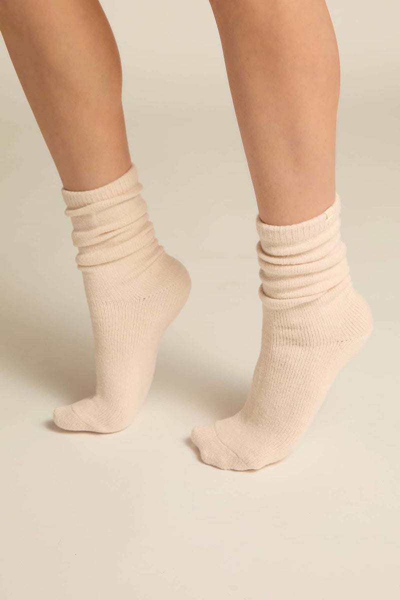 A pair of ivory luxury lounge socks fit on a person's feet, showcasing the crew height and the soft texture of the bamboo knit blend.