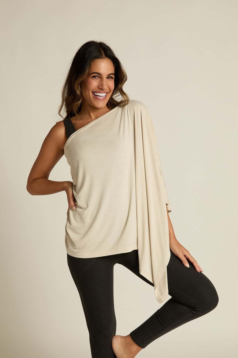 A woman is wearing a beige bamboo wrap that is lightweight and appears to be moisture-wicking. She is posing with one hand on her hip and a smile on her face.